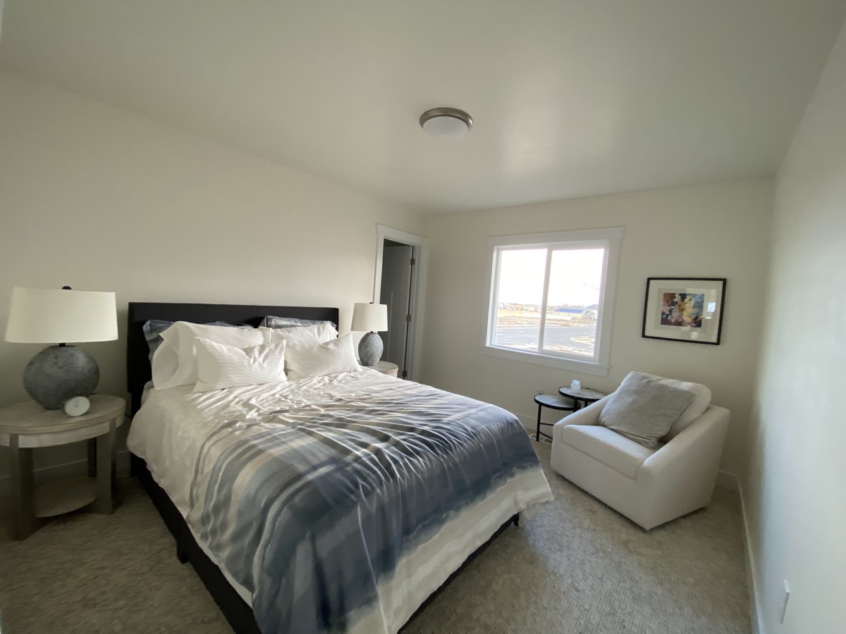 Bedroom with dark blue bedding and a reading chair