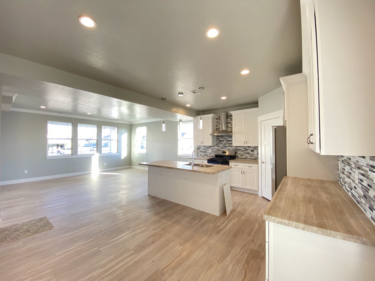 White kitchen opening into a long living area